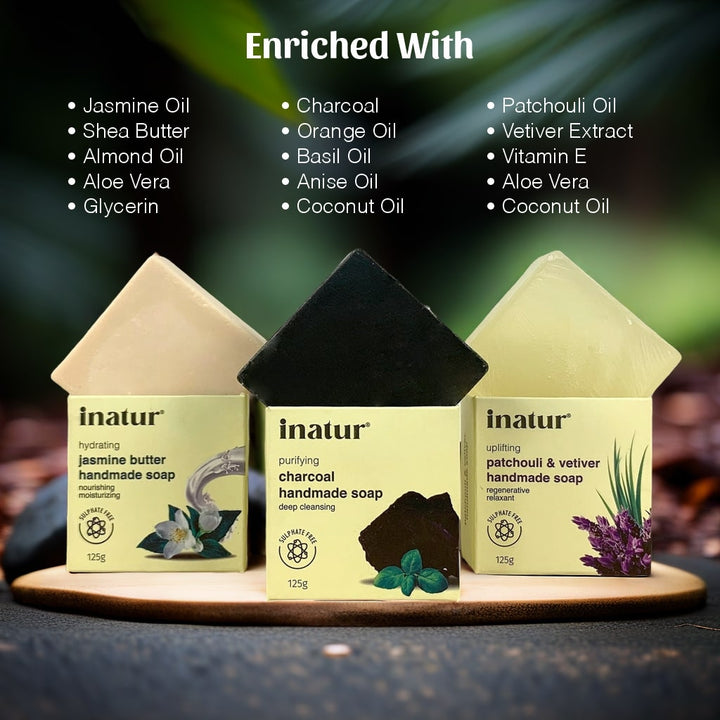 Three inatur handmade soaps on a wooden stand with text of its active ingredients like charcoal, shea butter, almond, aloe vera, glycerine, orange, basil, anise, coconut, patchouli, vetiver and jasmine oil